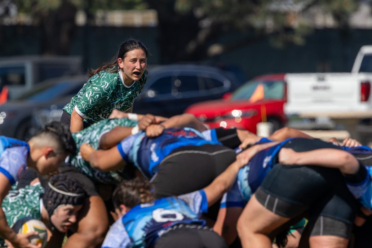 Rugby player breaking through a tackle